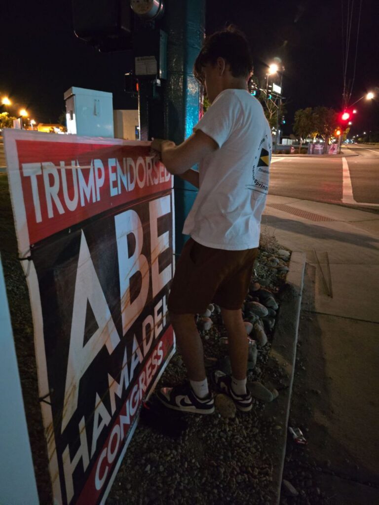 Nico Delgado Fixing a Trump Endorsed Abe Hamadeh for Congress Street Sign in Peoria