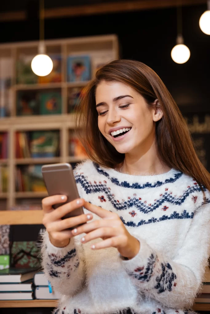 Young woman texting in a library